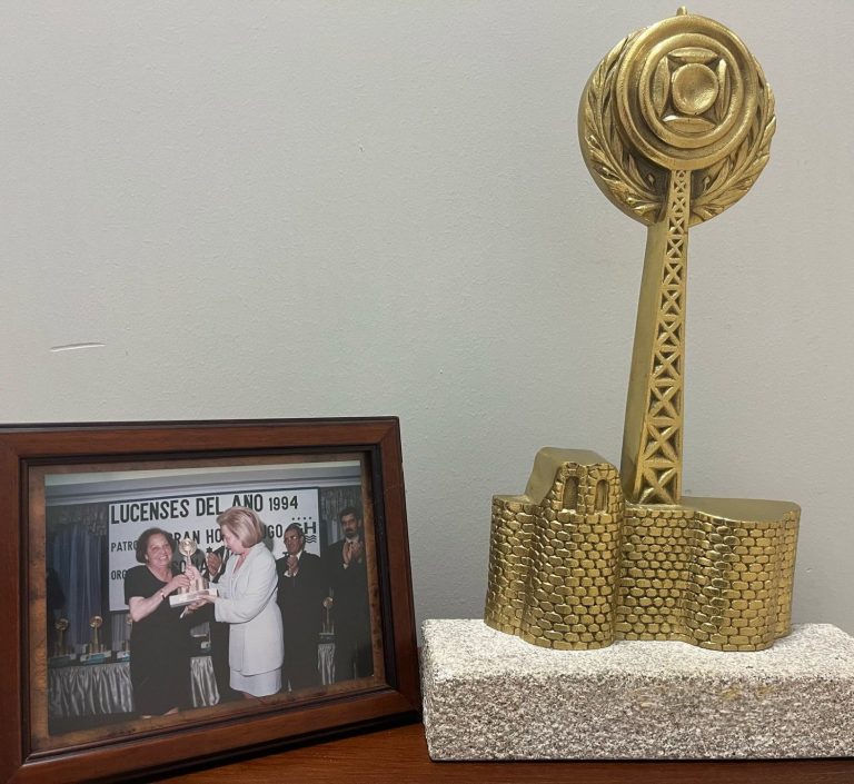 Estatua dorada de un edificio con una foto enmarcada de personas celebrando.