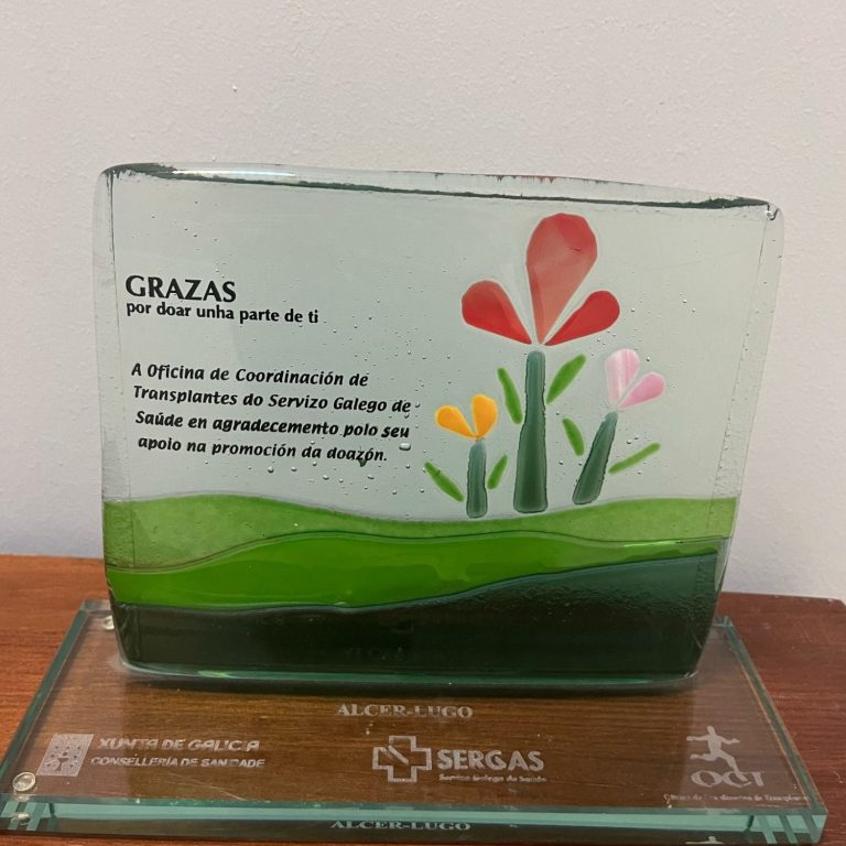 Trofeo de cristal con flores de colores y un mensaje de agradecimiento.