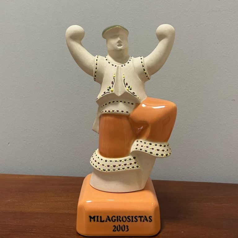 Estatua de cerámica con figura masculina levantando los brazos en señal de celebración.